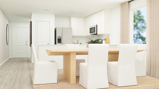 kitchen with light wood finished floors, baseboards, appliances with stainless steel finishes, light countertops, and white cabinetry