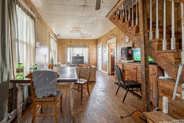 dining area featuring wood walls, stairway, and hardwood / wood-style floors