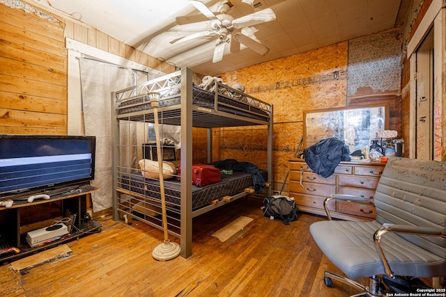 bedroom featuring wood walls and wood-type flooring