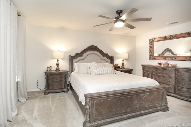 bedroom with light carpet, visible vents, and a ceiling fan