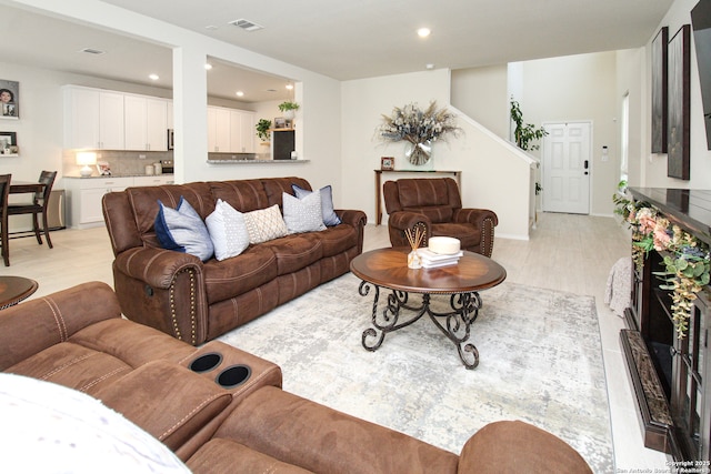 living area featuring light wood finished floors, stairway, visible vents, and recessed lighting