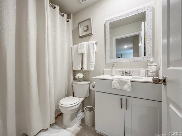 bathroom featuring toilet, visible vents, and vanity