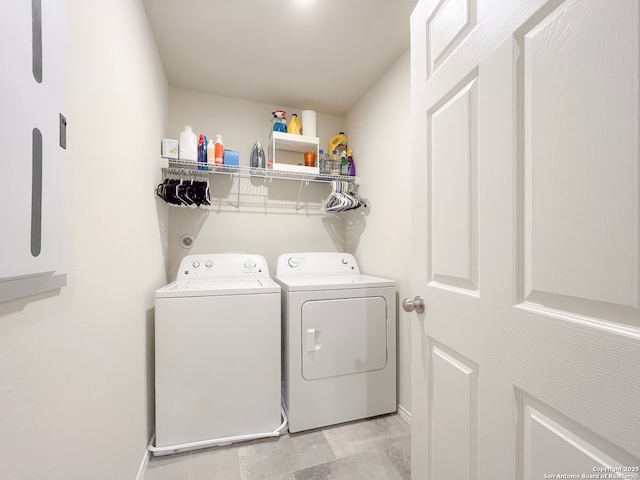 clothes washing area with laundry area, separate washer and dryer, and baseboards