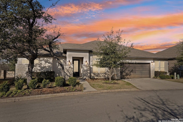 view of front facade with driveway, an attached garage, and stucco siding