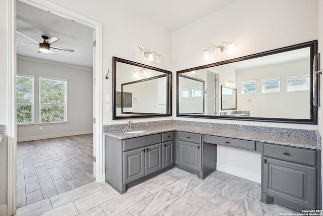 full bath featuring baseboards, ornamental molding, a ceiling fan, and vanity