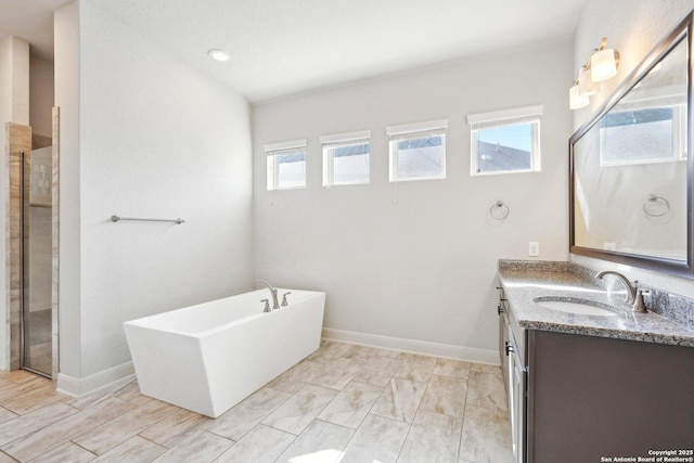 full bath with a soaking tub, a tile shower, vanity, and baseboards