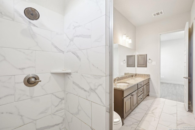 full bath with a tile shower, marble finish floor, a sink, and visible vents