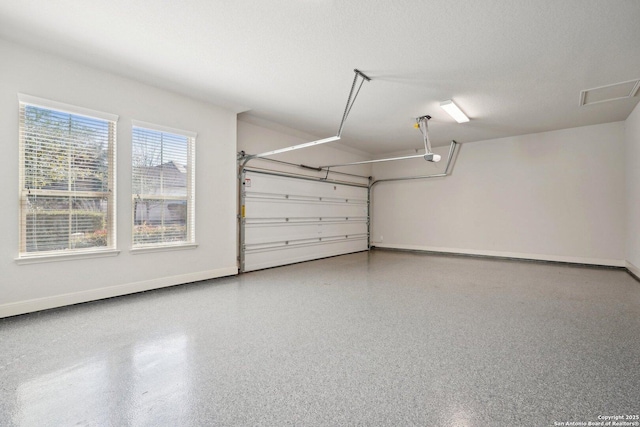 garage featuring a garage door opener and baseboards