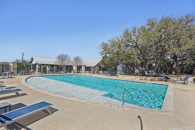 community pool featuring a patio area and fence