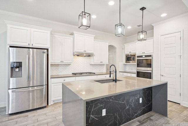 kitchen with a kitchen island with sink, a sink, white cabinetry, light countertops, and appliances with stainless steel finishes