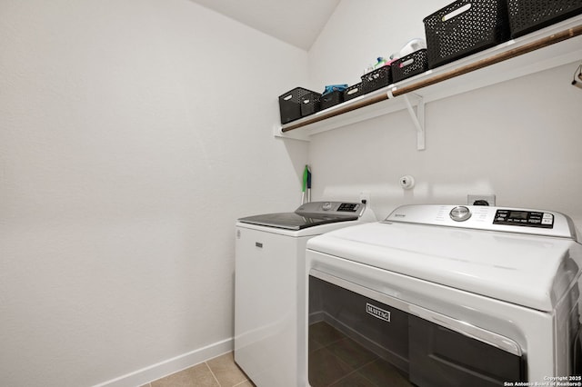 laundry area with laundry area, light tile patterned flooring, washing machine and dryer, and baseboards