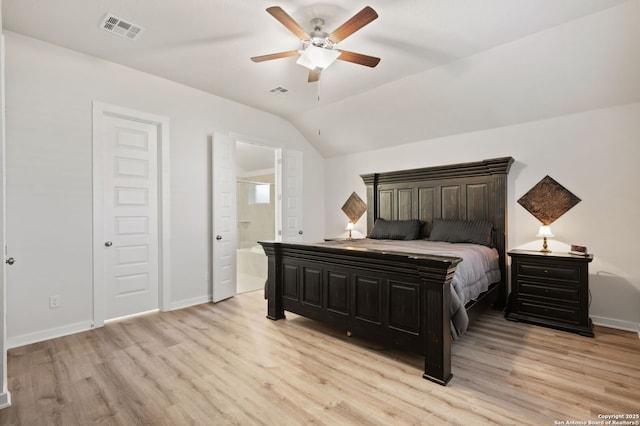 bedroom with visible vents, baseboards, ensuite bath, light wood-style flooring, and vaulted ceiling