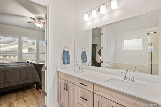 ensuite bathroom featuring connected bathroom, a ceiling fan, a sink, and wood finished floors