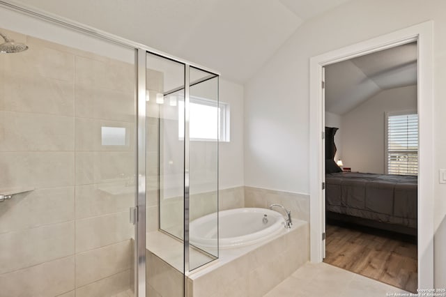 ensuite bathroom with a garden tub, lofted ceiling, ensuite bathroom, a shower stall, and wood finished floors