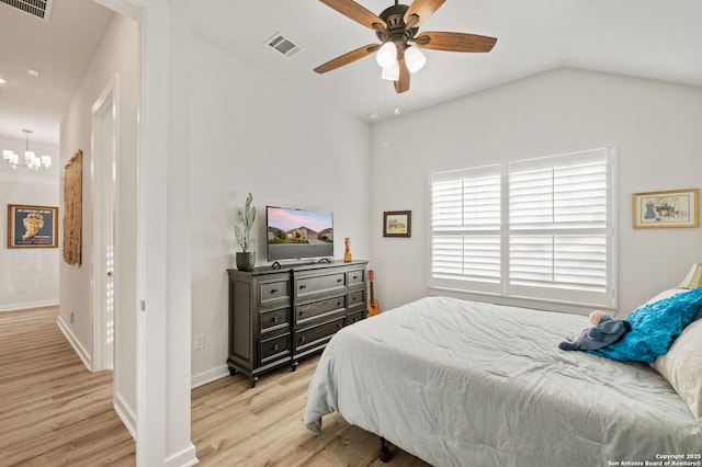 bedroom featuring lofted ceiling, light wood finished floors, visible vents, and baseboards