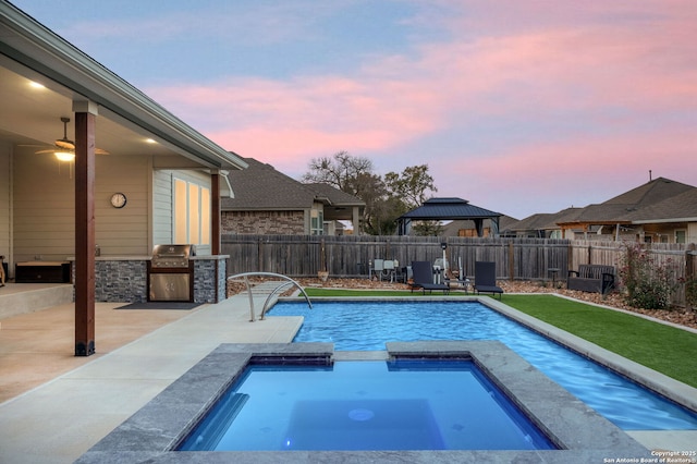 view of swimming pool featuring an outdoor kitchen, a fenced backyard, an in ground hot tub, a gazebo, and a fenced in pool