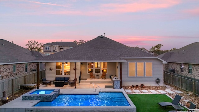 back of house at dusk with a lawn, a fenced backyard, an outdoor hangout area, a patio area, and a pool with connected hot tub