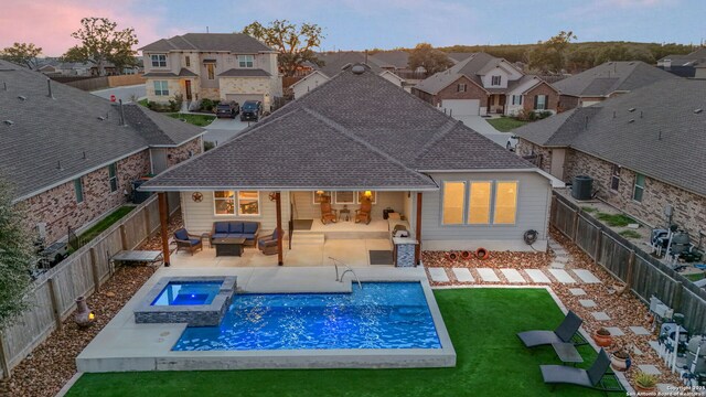 pool at dusk with a fenced backyard, central air condition unit, an outdoor living space, a yard, and a residential view