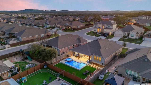 aerial view at dusk featuring a residential view