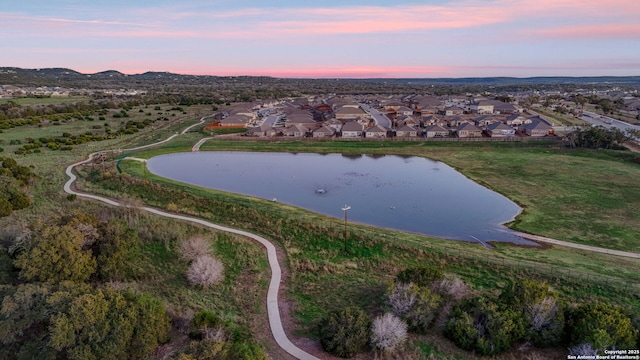 aerial view at dusk with a residential view and a water view