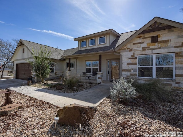 view of front of house featuring a garage, stone siding, and concrete driveway