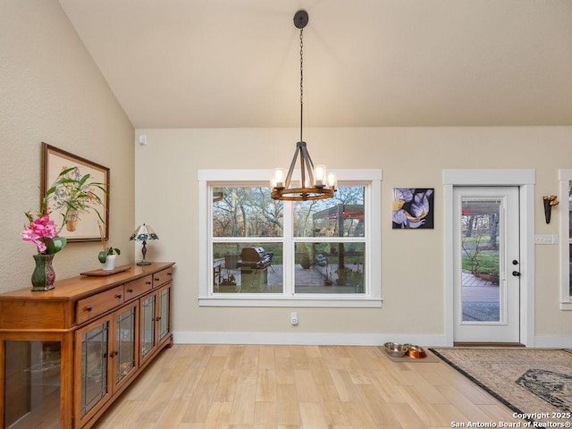 dining room with light wood-type flooring, baseboards, and a chandelier