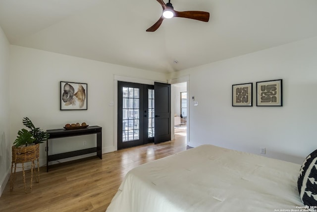 bedroom featuring baseboards, lofted ceiling, wood finished floors, access to outside, and french doors