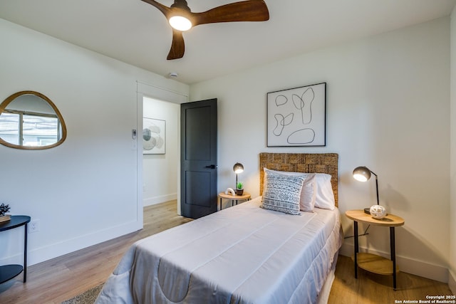 bedroom with light wood finished floors, ceiling fan, and baseboards