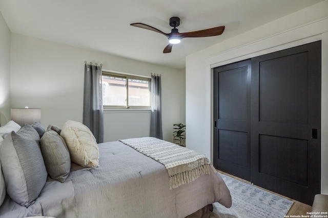 bedroom featuring ceiling fan, a closet, and wood finished floors