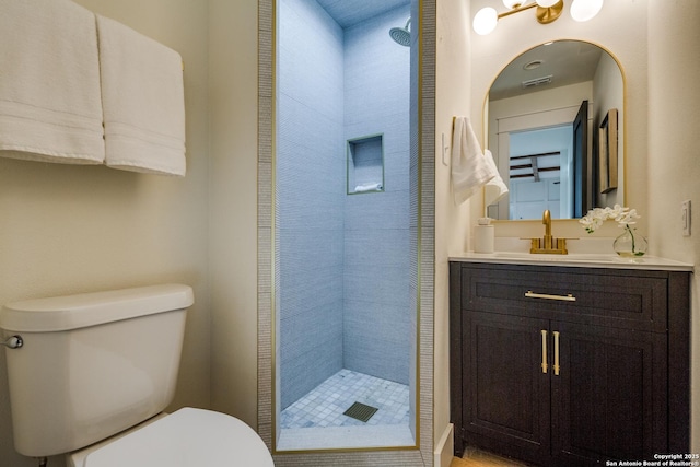 bathroom featuring visible vents, a shower stall, toilet, and vanity