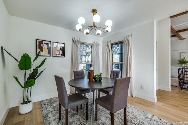 dining room with baseboards, wood finished floors, and a notable chandelier