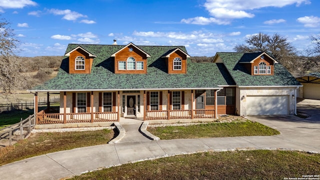 view of front of house featuring covered porch, roof with shingles, and driveway