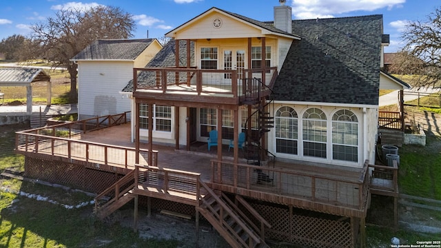 rear view of house featuring french doors, a patio, a chimney, a shingled roof, and a wooden deck