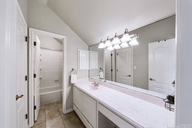 bathroom featuring tub / shower combination, vaulted ceiling, vanity, a textured ceiling, and tile patterned floors