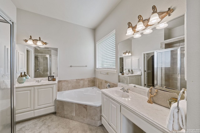 bathroom featuring two vanities, a garden tub, a sink, and a shower stall