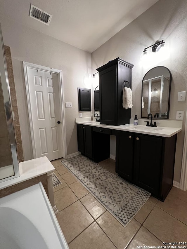 full bath featuring two vanities, visible vents, a sink, and tile patterned floors