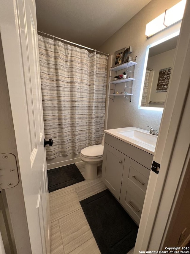 full bathroom with a textured wall, toilet, tile patterned flooring, shower / bath combo with shower curtain, and vanity