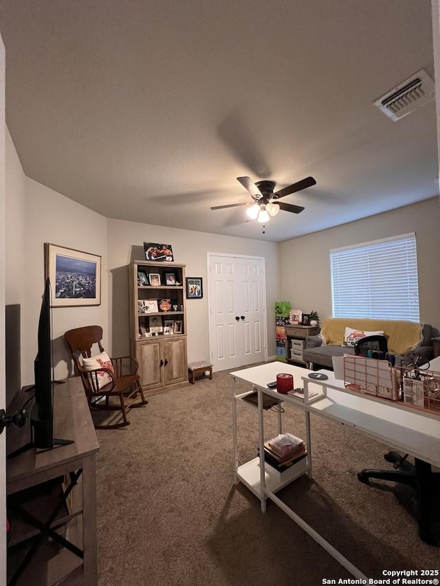 carpeted living room with visible vents and a ceiling fan