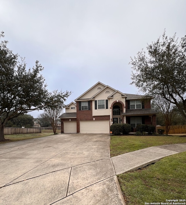 raised ranch featuring a garage, concrete driveway, a front lawn, and fence