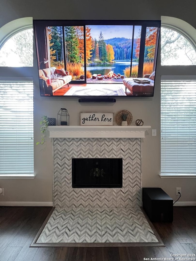 interior details featuring a fireplace, baseboards, and wood finished floors