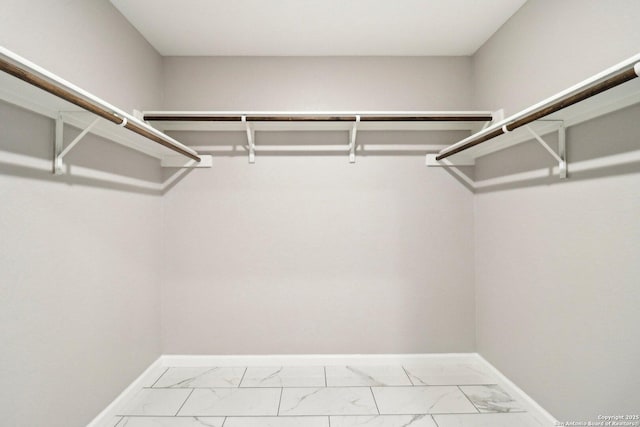 spacious closet featuring marble finish floor