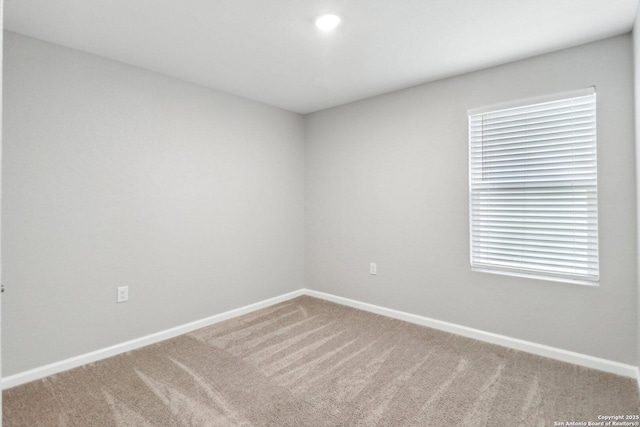 carpeted spare room with baseboards