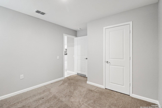 unfurnished bedroom featuring light carpet, visible vents, and baseboards