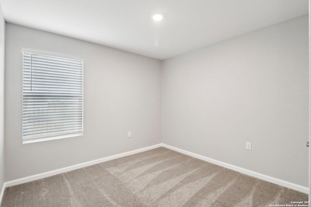 carpeted spare room featuring baseboards