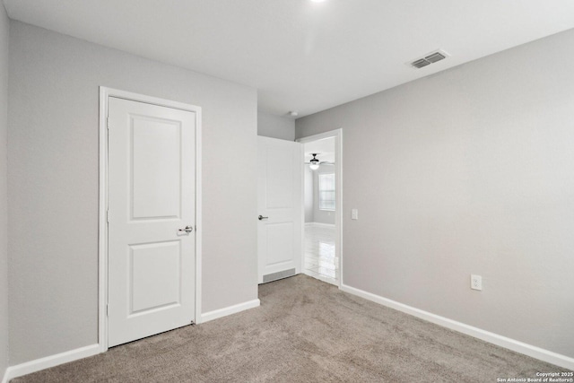 unfurnished bedroom with light carpet, visible vents, and baseboards