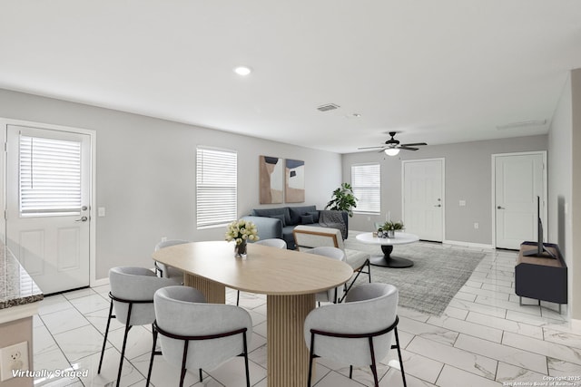 dining room with marble finish floor, a ceiling fan, visible vents, and baseboards