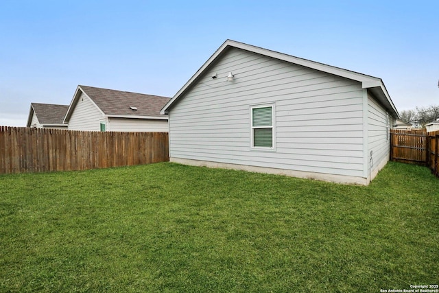 view of property exterior with fence private yard and a yard