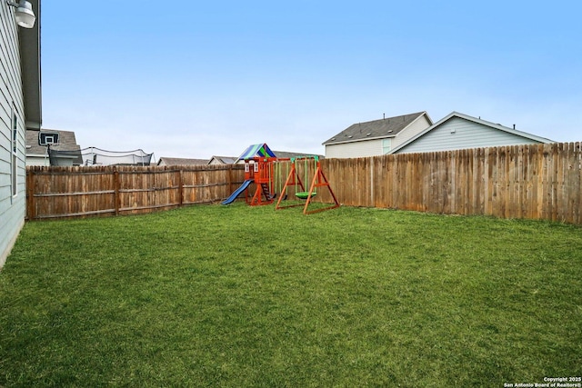 view of yard with a fenced backyard and a playground