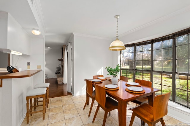 dining space with light tile patterned floors and crown molding