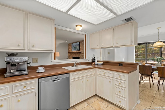 kitchen with visible vents, dishwasher, dark countertops, decorative light fixtures, and a sink